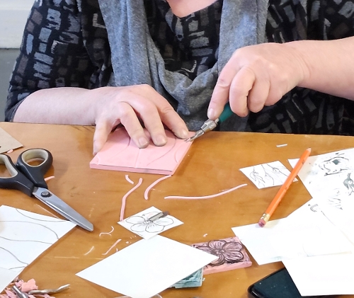 A student carves a block for fabric print.